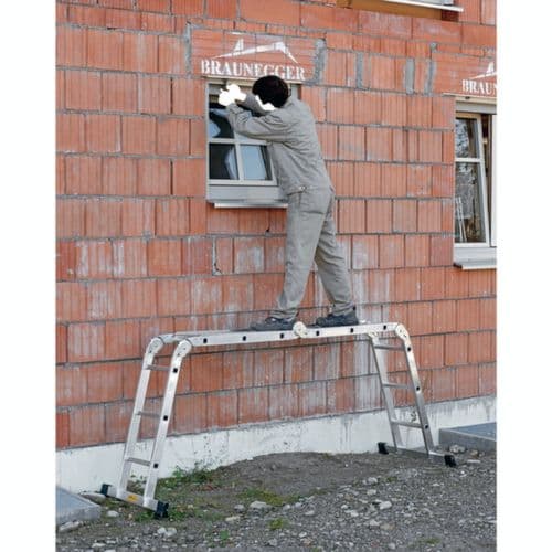 Arbeiter steht auf einer Steighilfe und führt Arbeiten an einer Hauswand aus