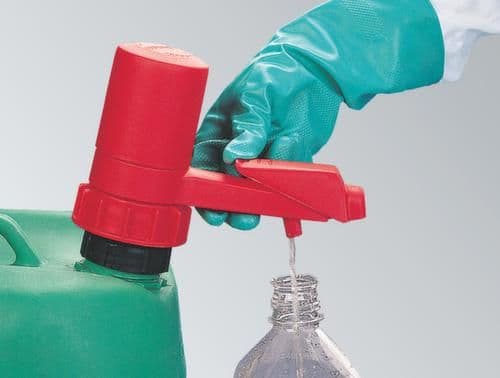 Chemikalien werden mit Schutzhandschuhen aus einem Kanister in ein kleineres Gefäß umgefüllt