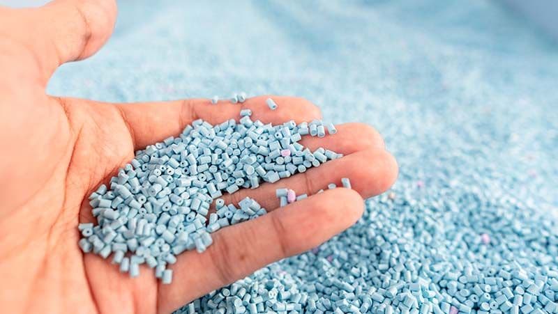 Kunststoffgranulat in der Hand als Ausgangsmaterial für Kunststoffprodukte